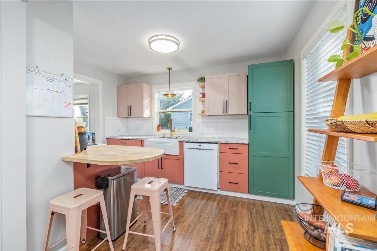 Kitchen featuring dark wood finished floors, open shelves, pendant lighting, backsplash, and white dishwasher