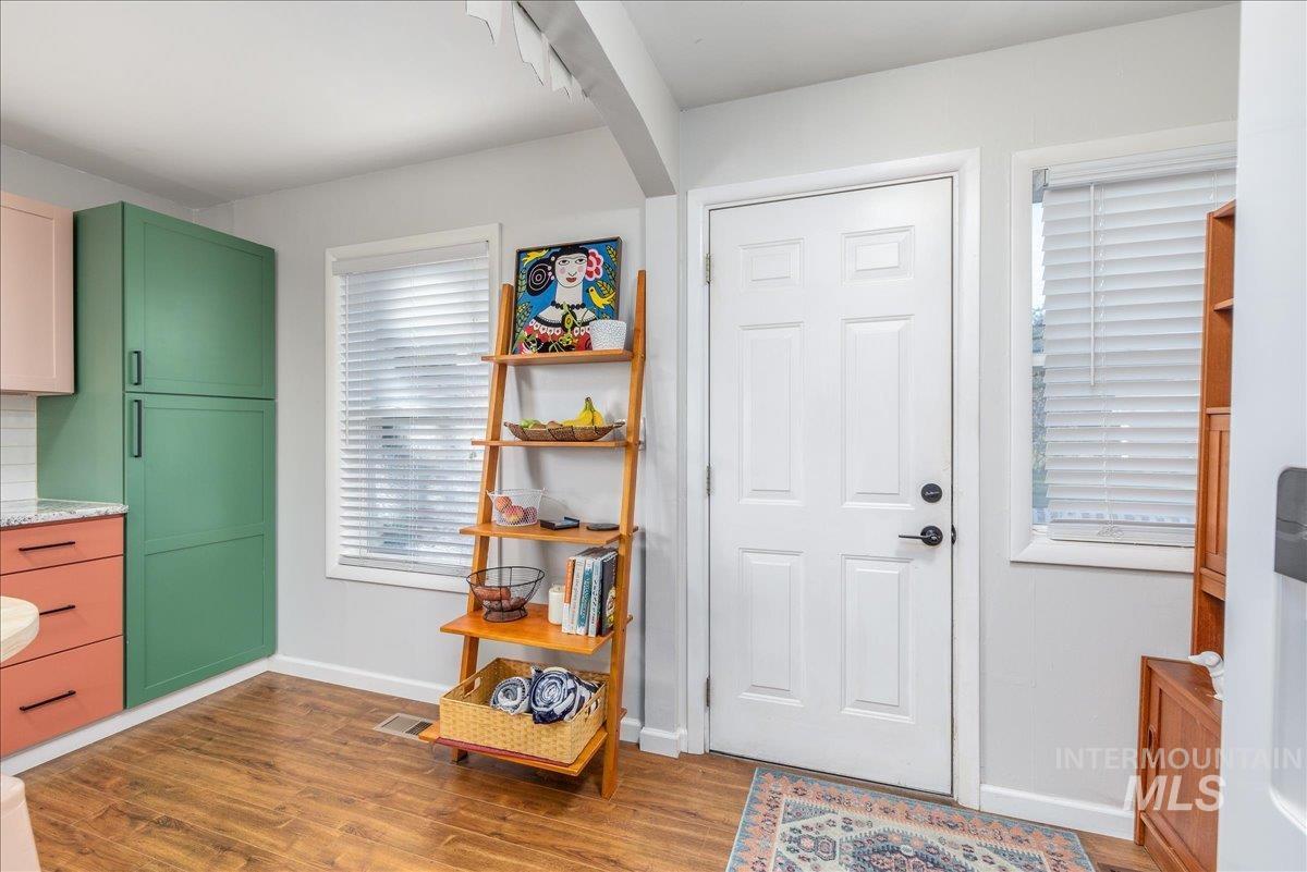 Foyer with baseboards and dark wood-style flooring