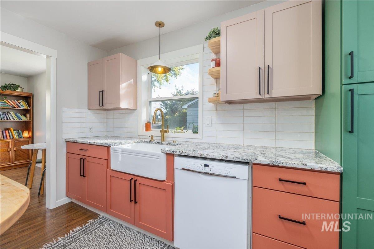 Kitchen with dishwasher, open shelves, dark wood-style flooring, tasteful backsplash, and pendant lighting
