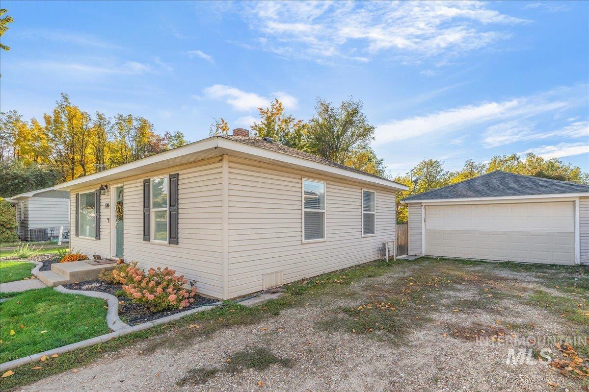 View of side of home featuring an outdoor structure and a detached garage