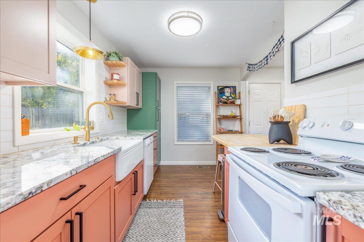 Kitchen featuring white appliances, backsplash, dark wood-style flooring, open shelves, and light stone countertops