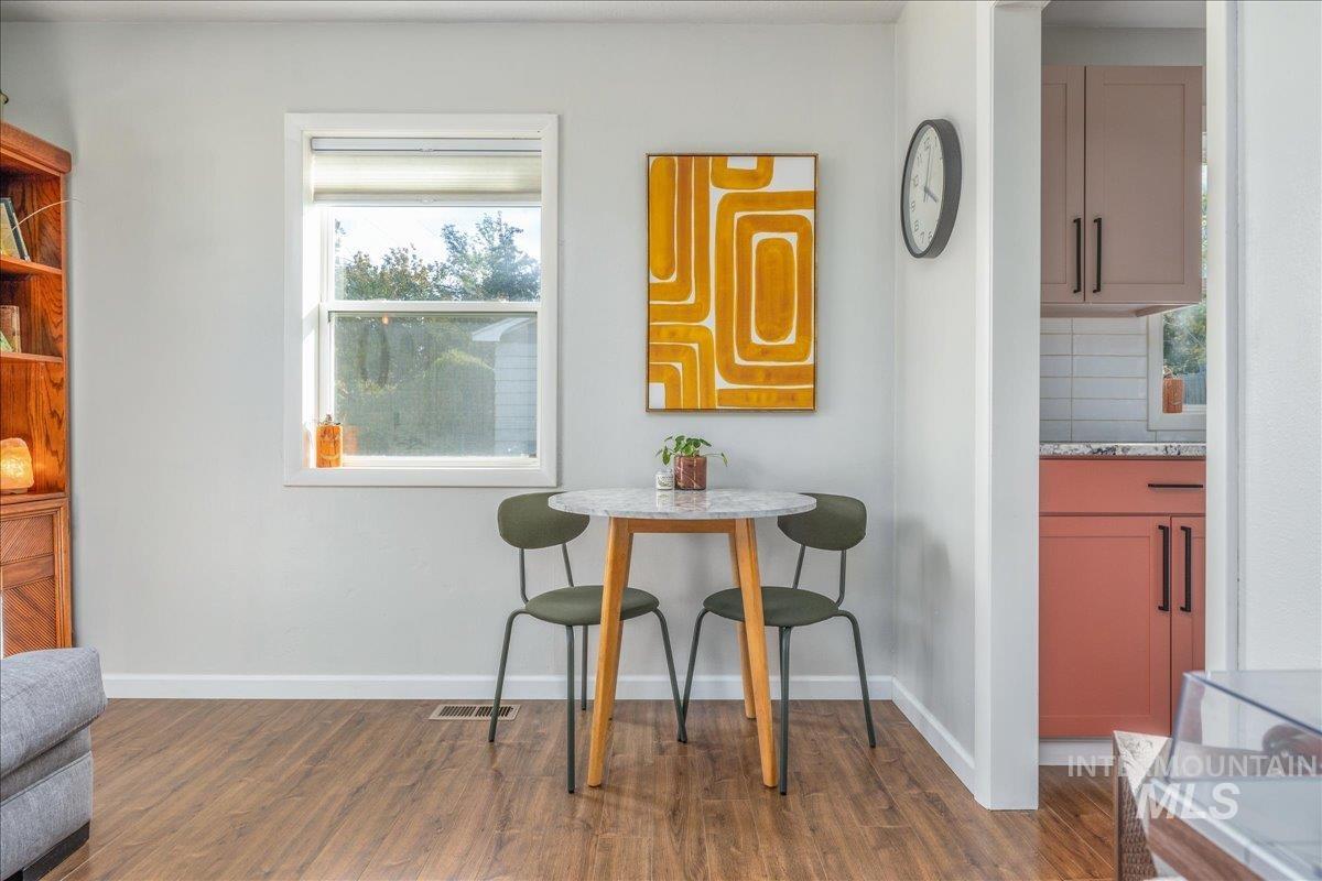 Dining space featuring dark wood-style flooring and baseboards