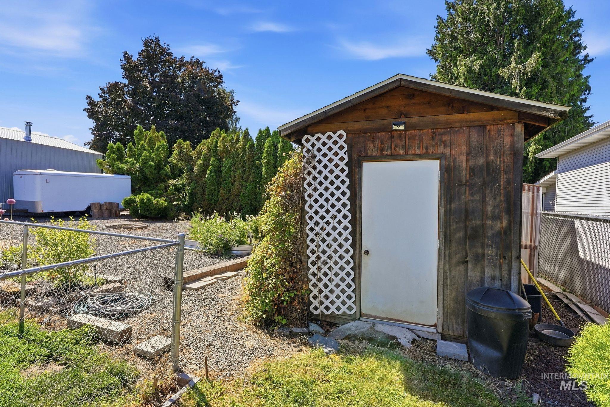 Wood-sided storage shed with a white entry door