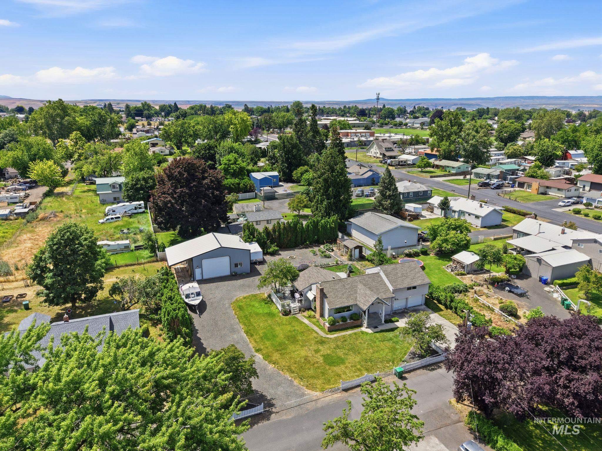 Aerial perspective showcasing a single-story residence with a light gray exterior and dark gray roof