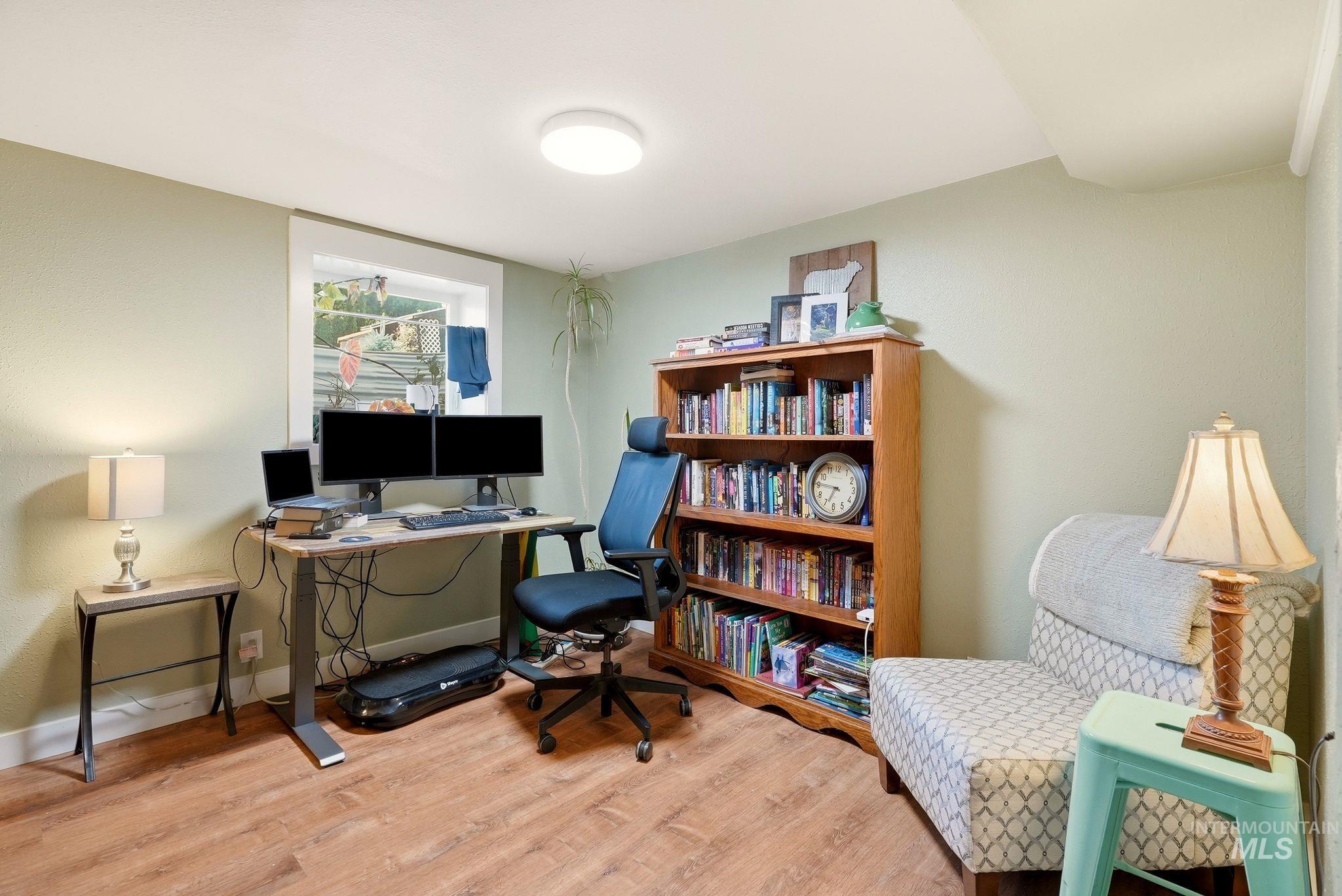 Wood-finish flooring and light green walls define this versatile room