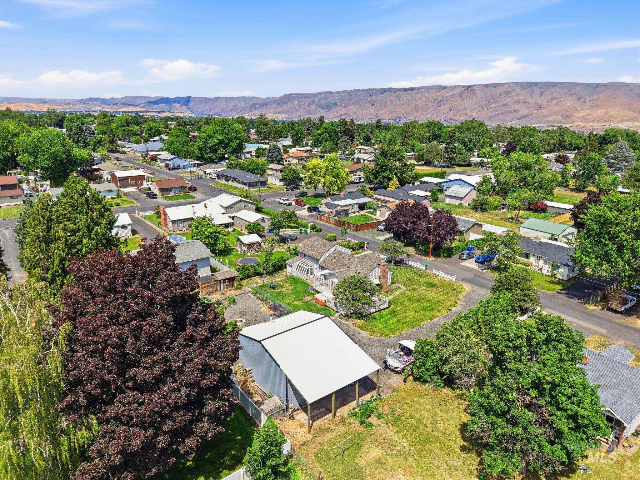 Aerial perspective of a residential area featuring established homes and mature trees