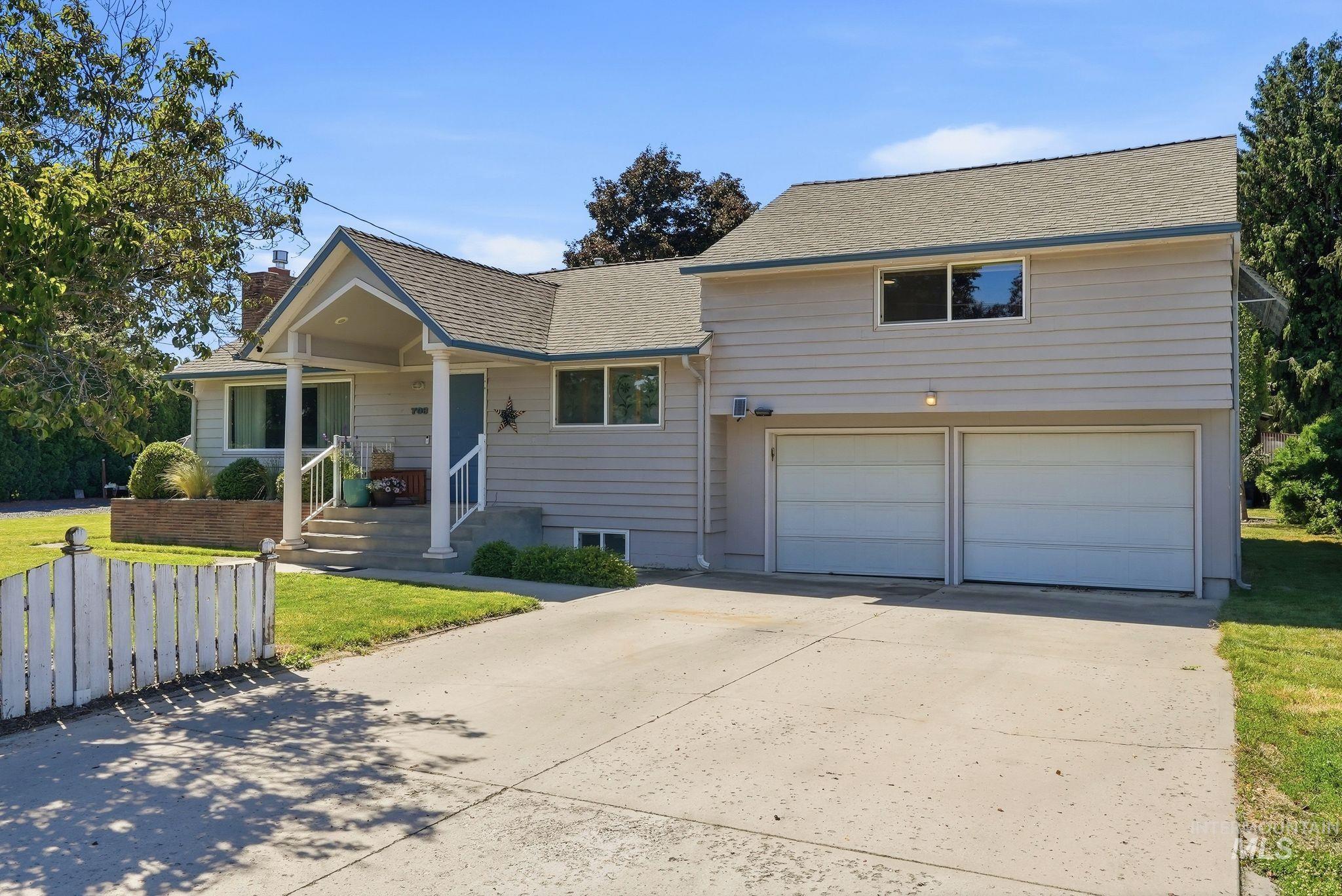 Single-family residence featuring a prominent covered front entry porch with white columns and railing