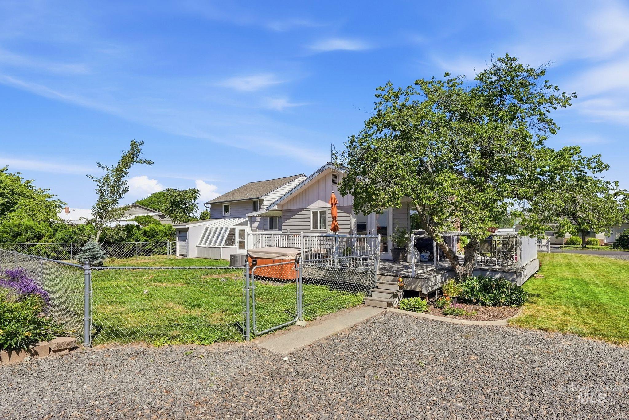 Expansive gravel driveway leading to a multi-level wooden deck