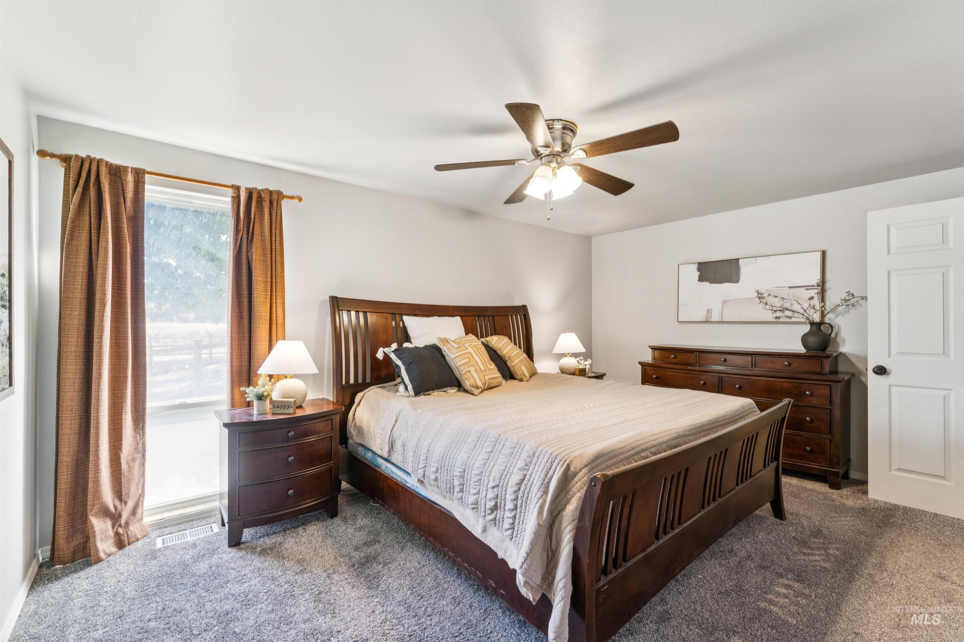Carpeted bedroom with a ceiling fan