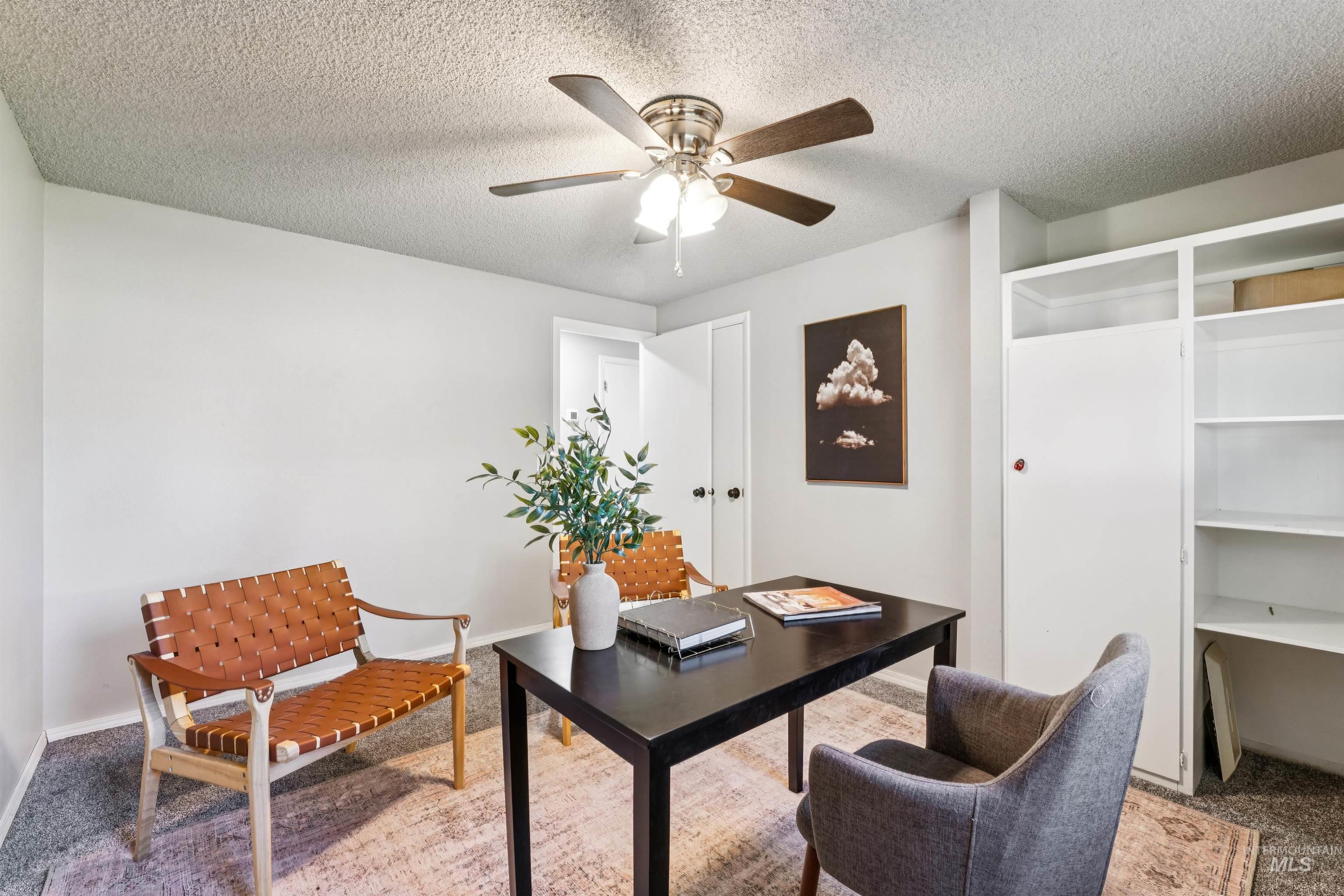 Office space featuring carpet, a textured ceiling, and a ceiling fan