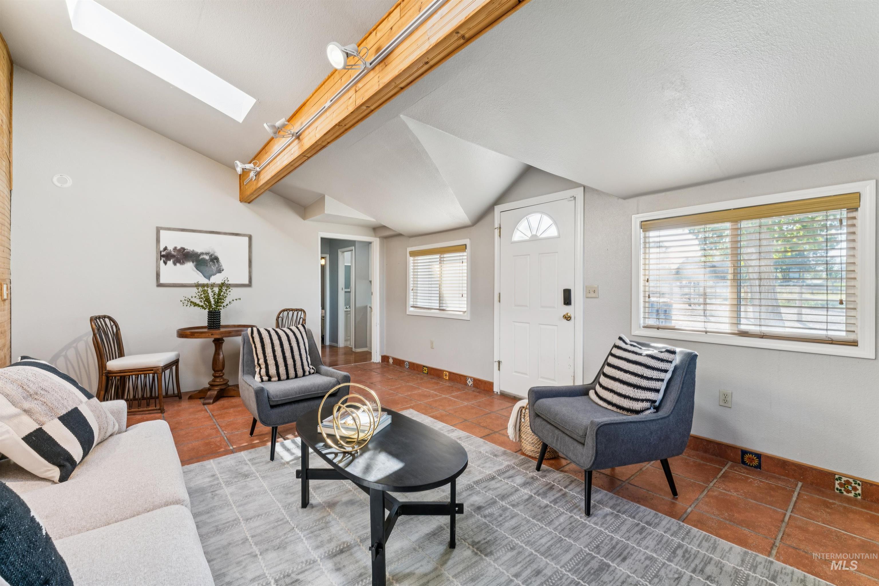 Tiled living area with vaulted ceiling and a skylight