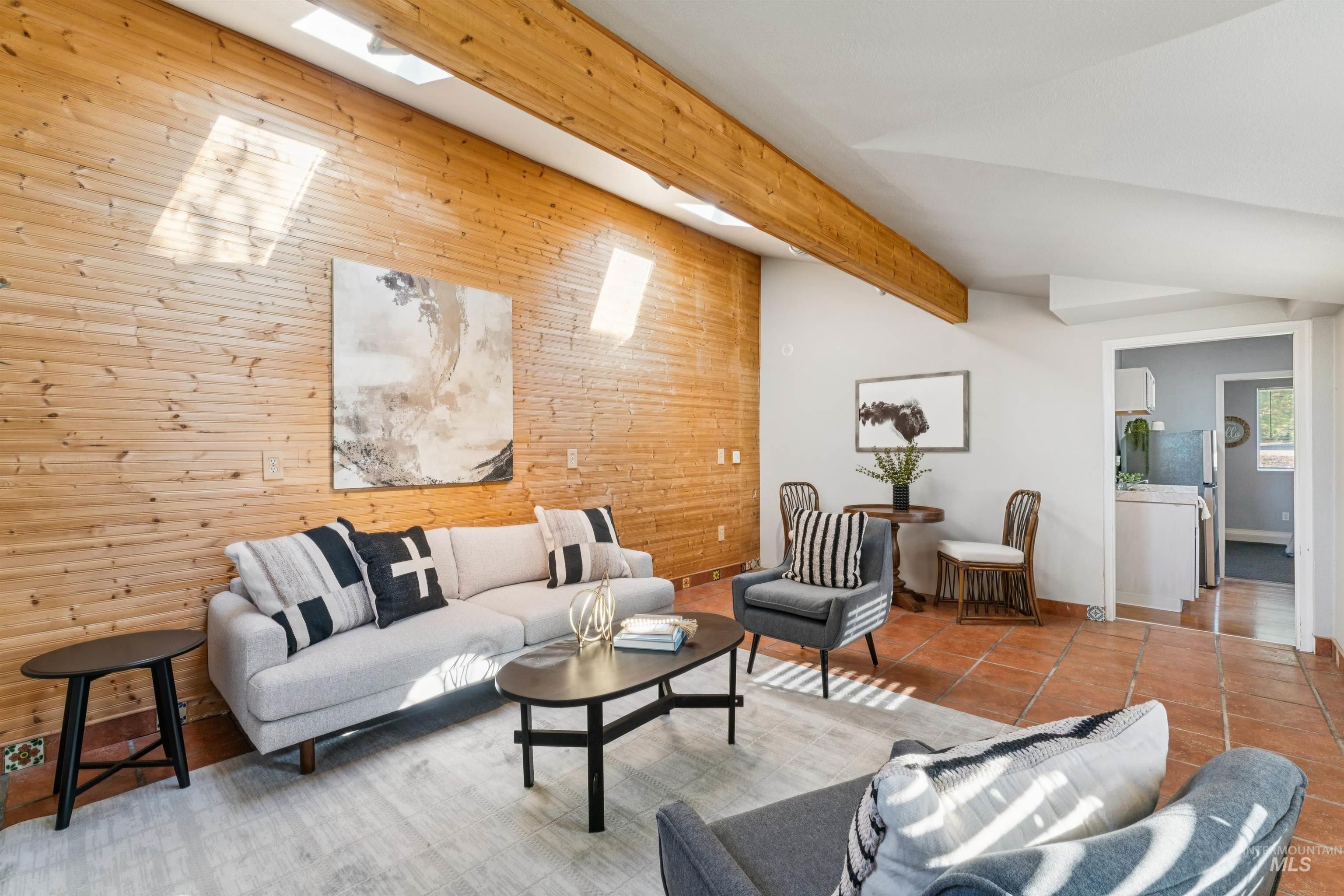 Tiled living area featuring wooden walls and baseboards