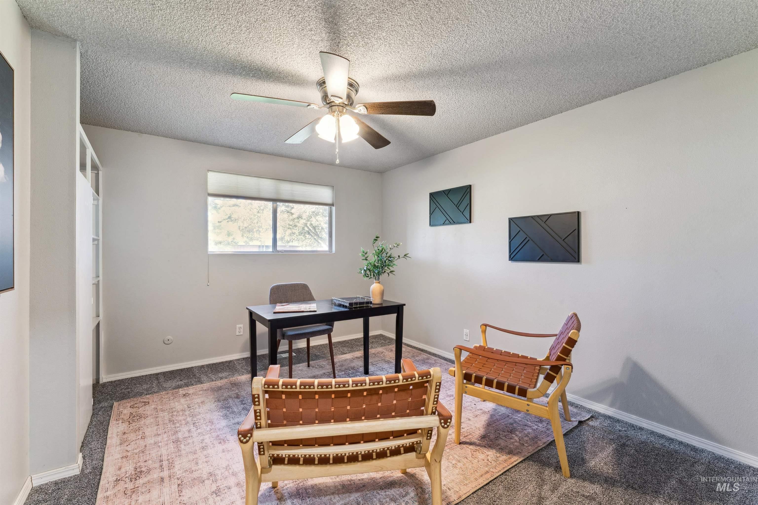 Office area featuring carpet floors, a textured ceiling, and a ceiling fan