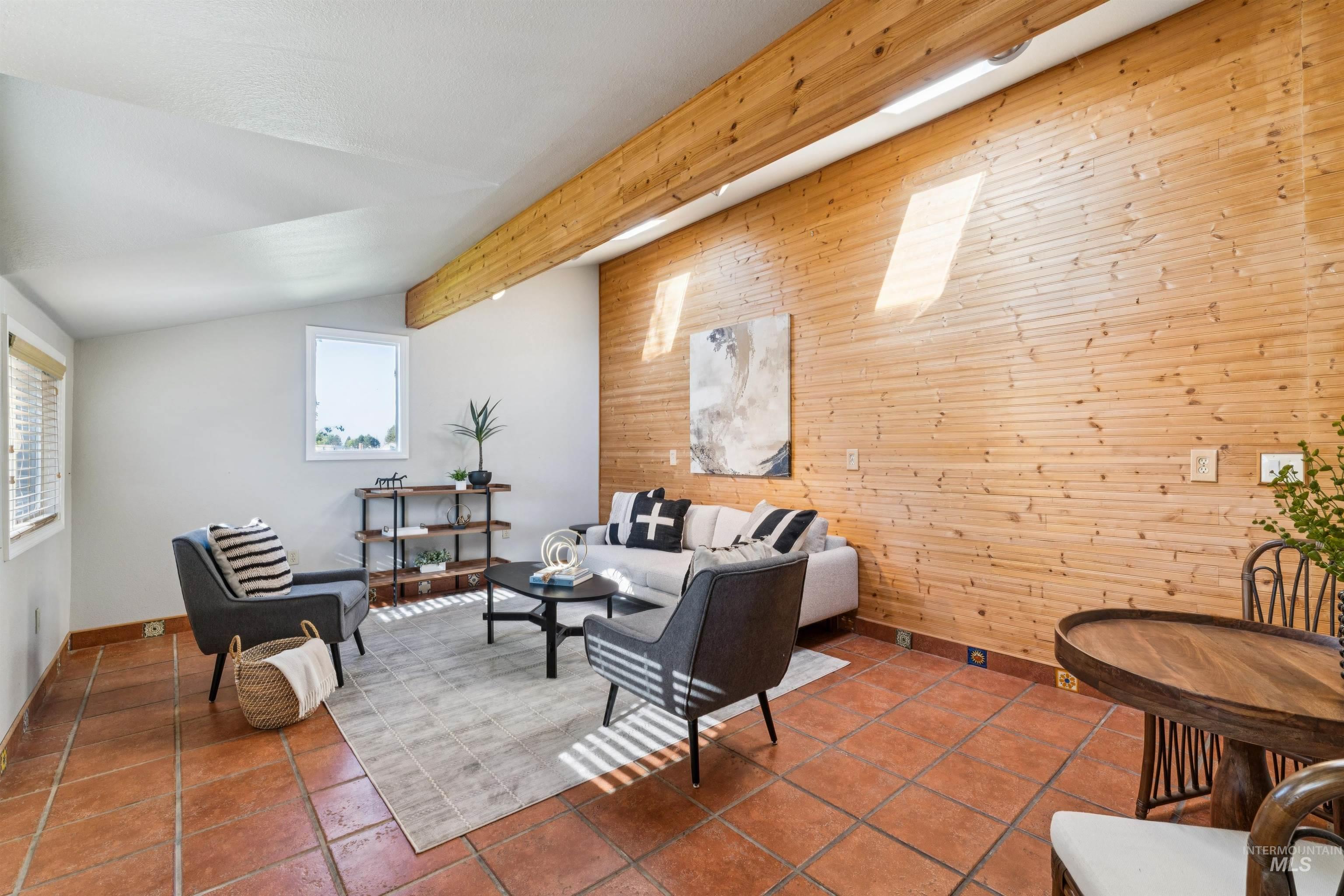 Living room with wooden walls and tile patterned flooring