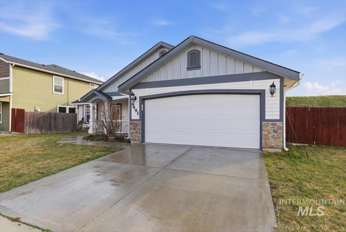 Single story home featuring stone siding, board and batten siding, concrete driveway, and an attached garage