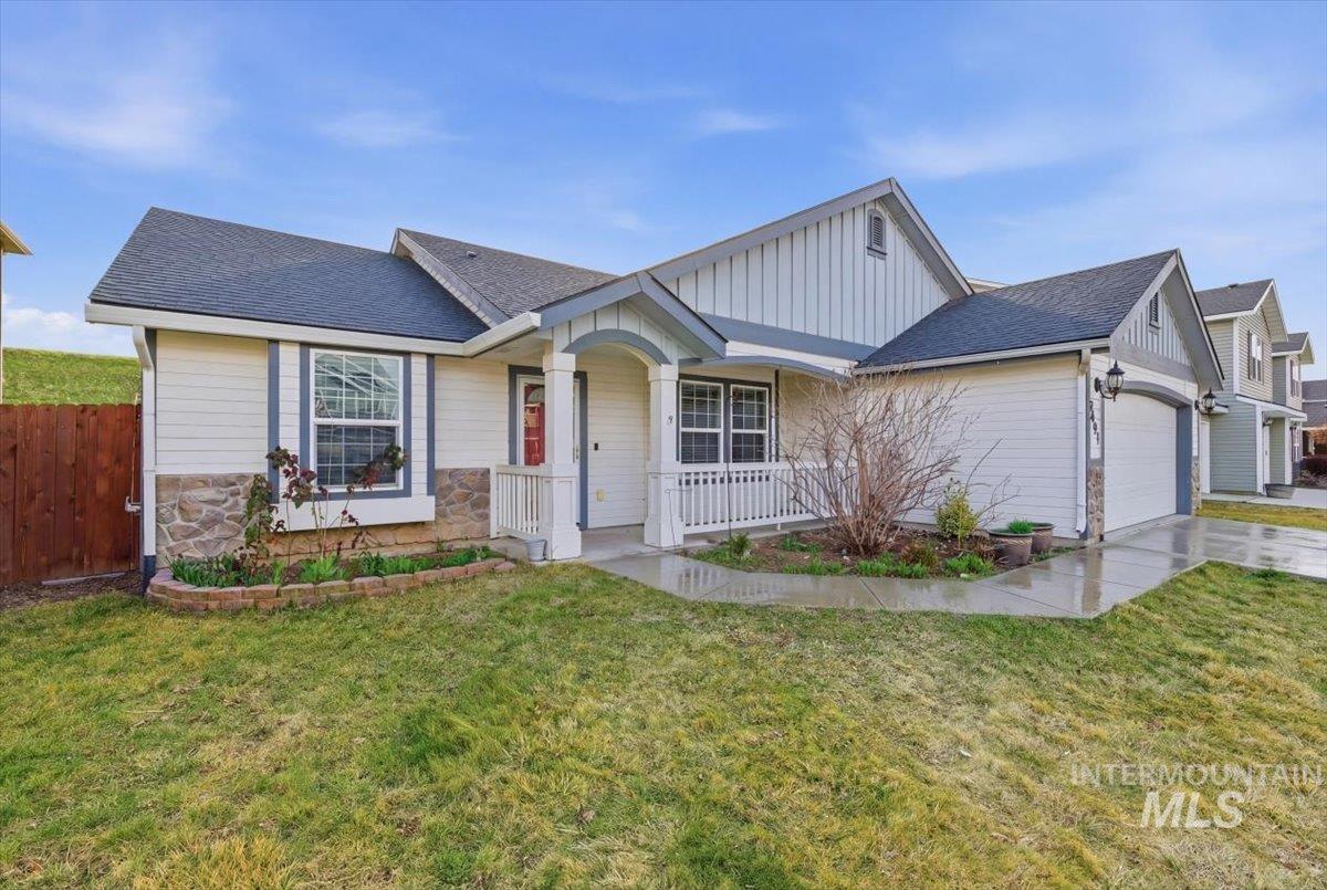 View of front of property featuring a shingled roof, an attached garage, board and batten siding, and covered porch