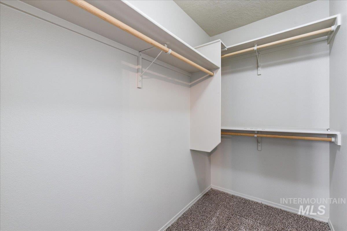 Walk in closet featuring dark carpet