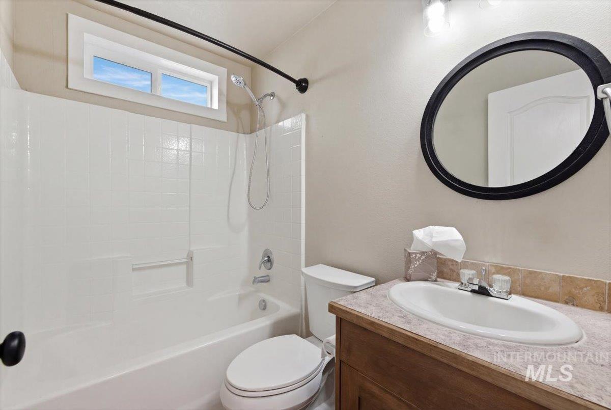 Full bath with vanity, tub / shower combination, and a textured wall