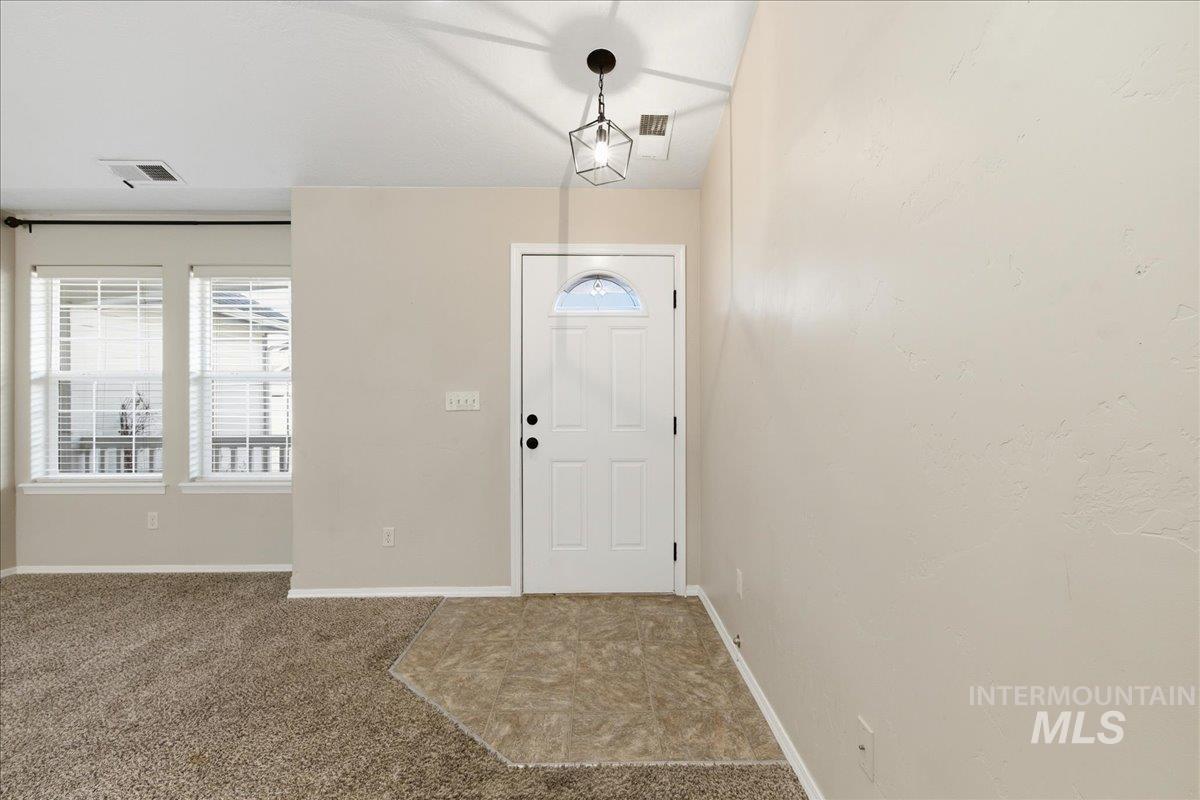 Foyer entrance featuring carpet floors and baseboards