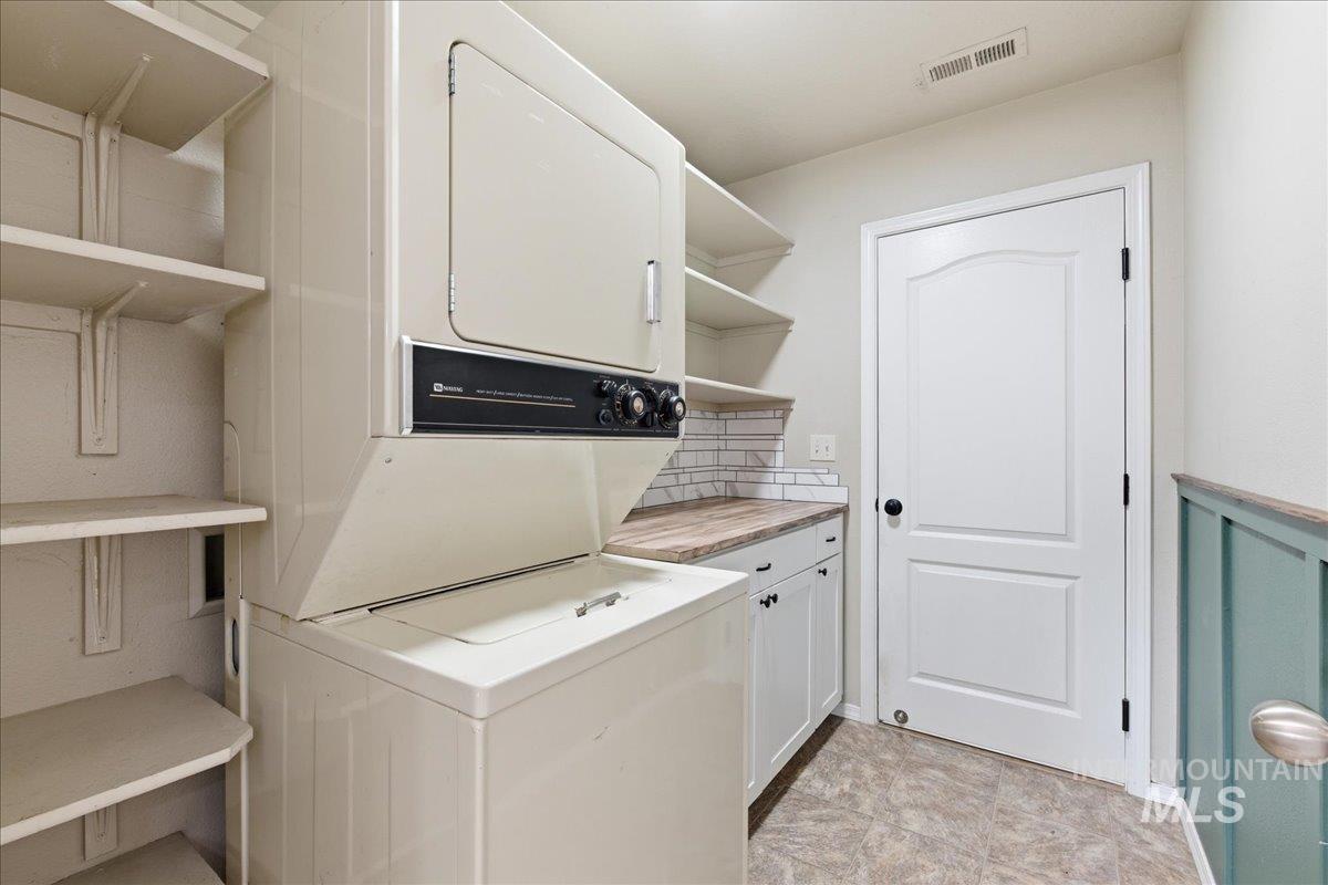 Laundry area with stacked washing machine and dryer and cabinet space