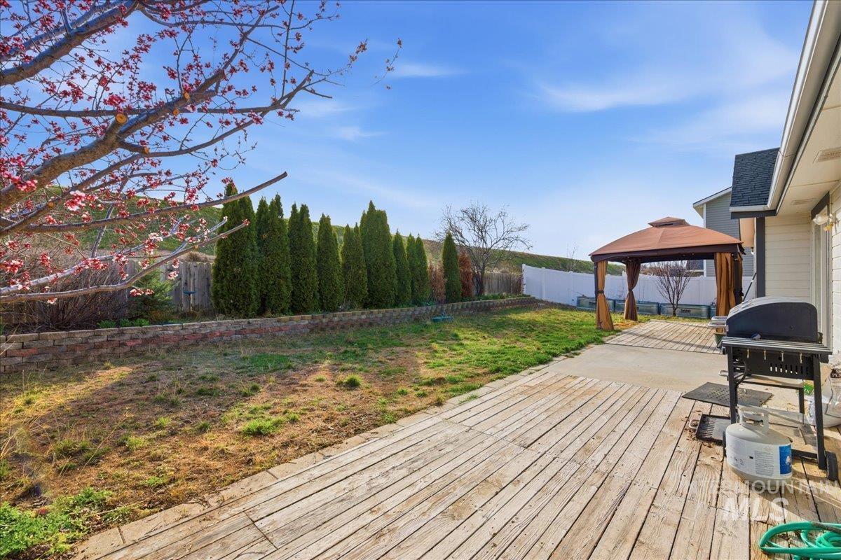 Deck featuring a gazebo, grilling area, and a fenced backyard