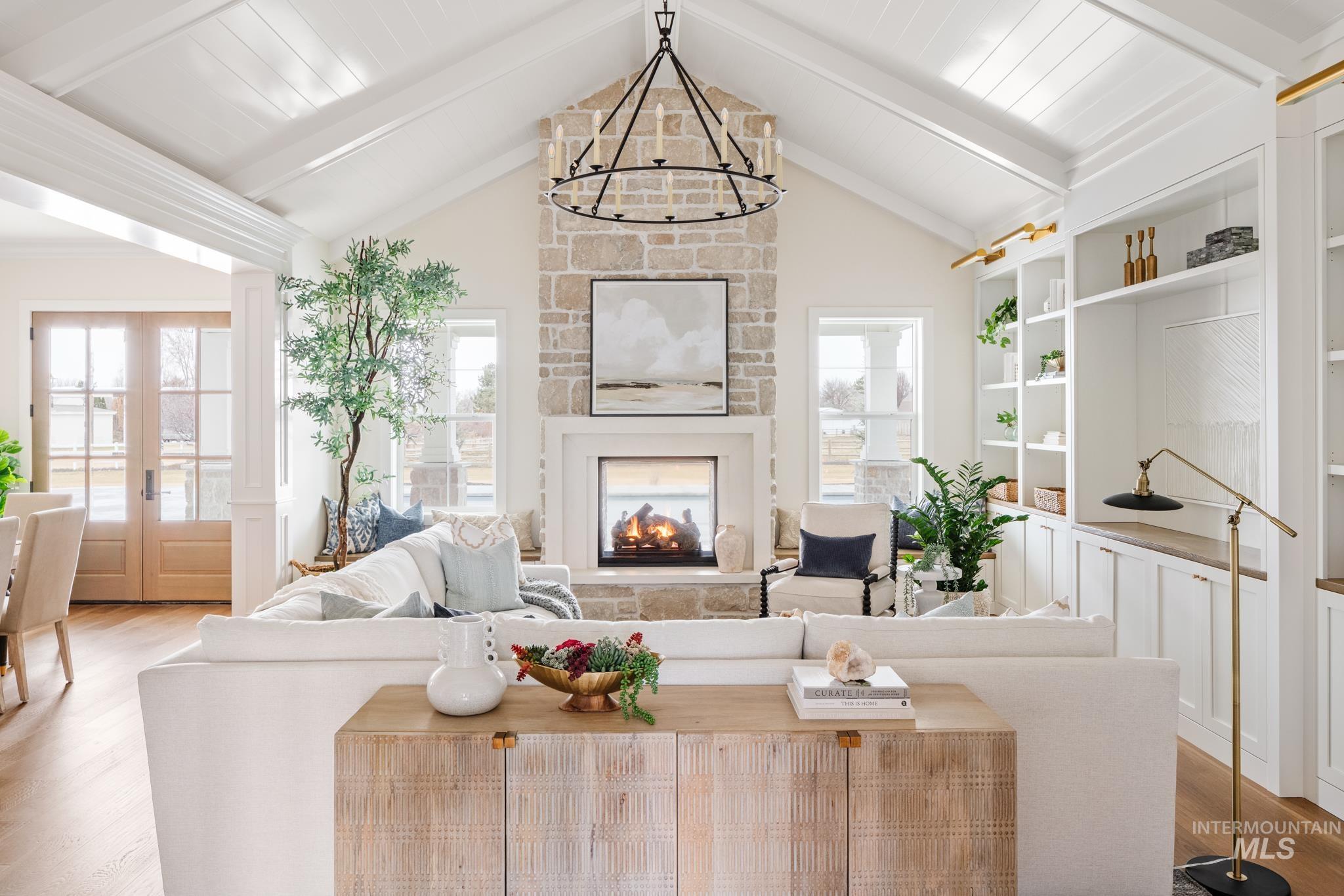 Living area featuring wood finished floors, a fireplace, french doors, and a chandelier