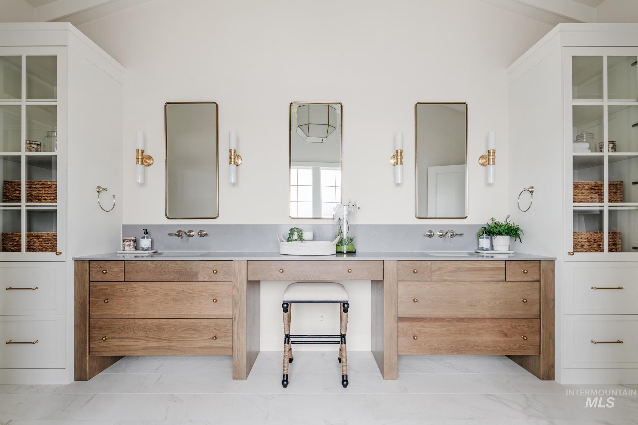 Full bath featuring double vanity and light marble finish floors