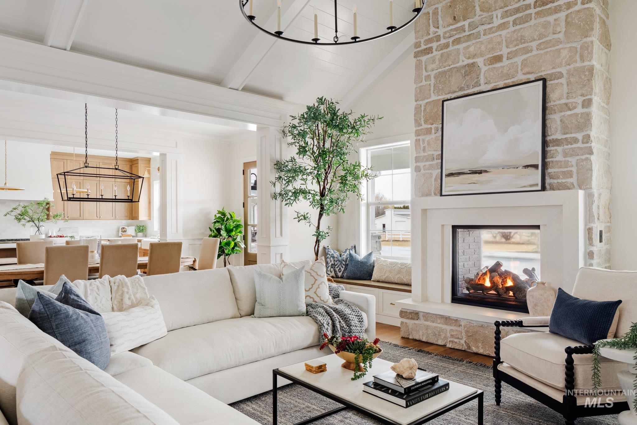 Living room with a chandelier, wood finished floors, and a fireplace
