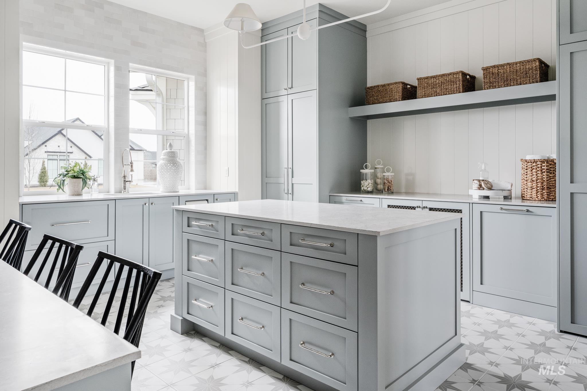 Kitchen featuring gray cabinetry, open shelves, a kitchen island, light stone countertops, and light floors