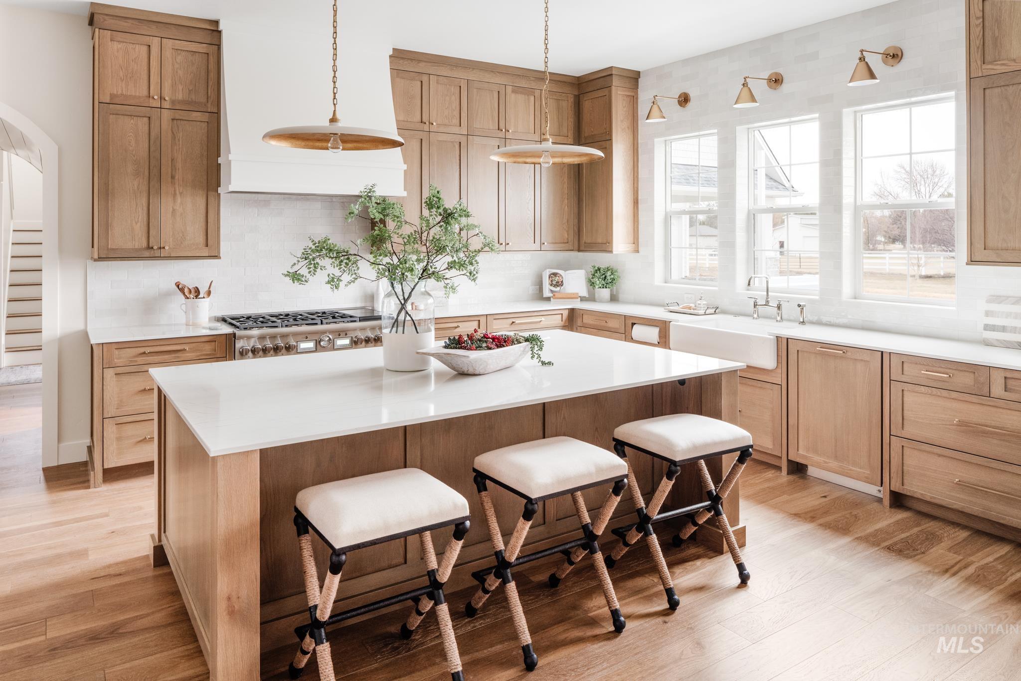 Kitchen featuring backsplash, a kitchen bar, premium range hood, and a kitchen island