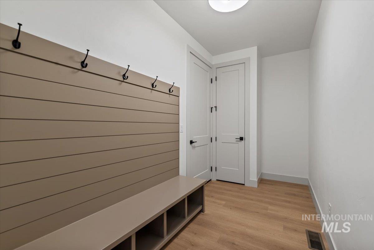 Mudroom with light wood-style flooring and baseboards