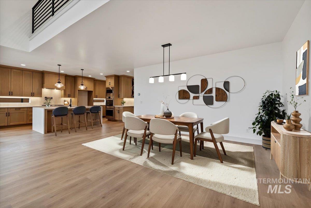 Dining area with light wood-style floors and recessed lighting