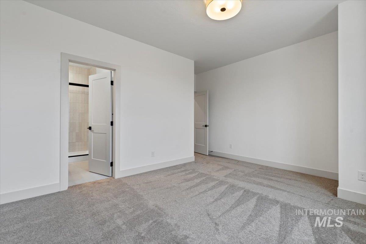 Unfurnished bedroom featuring light carpet and baseboards