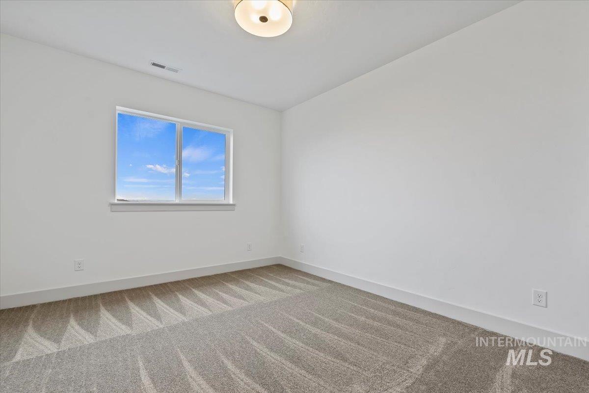 Carpeted spare room with baseboards
