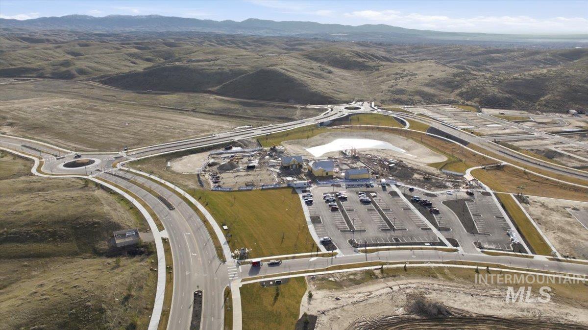 Aerial view of property and surrounding area featuring a mountainous background
