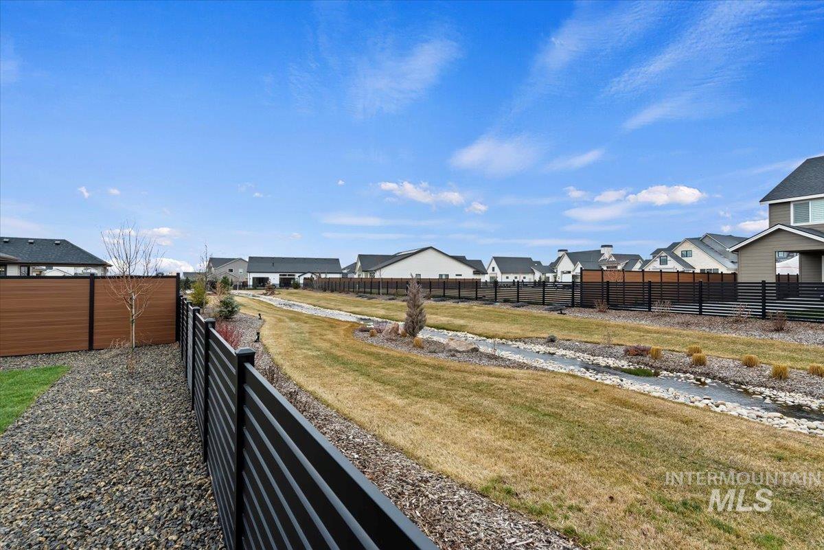 Fenced yard featuring a residential view