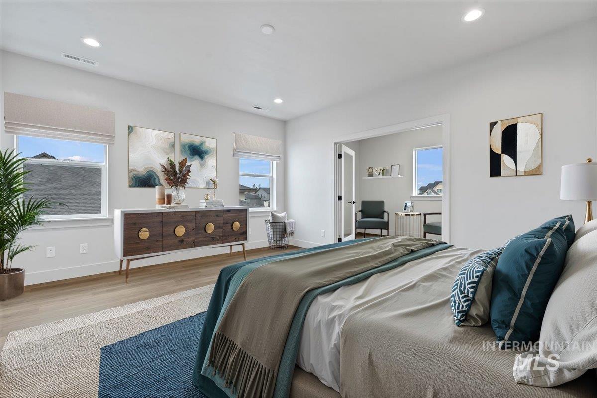 Bedroom with wood finished floors and recessed lighting