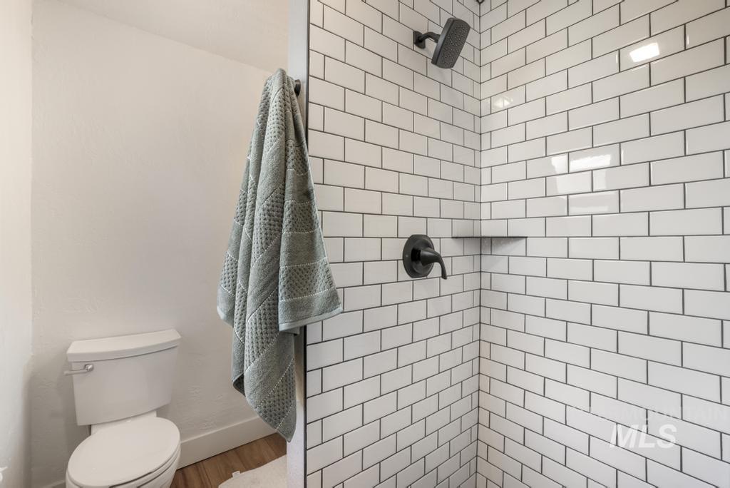 Full bathroom featuring a tile shower and toilet