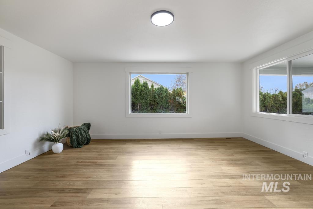 Unfurnished room featuring light wood-style floors and baseboards