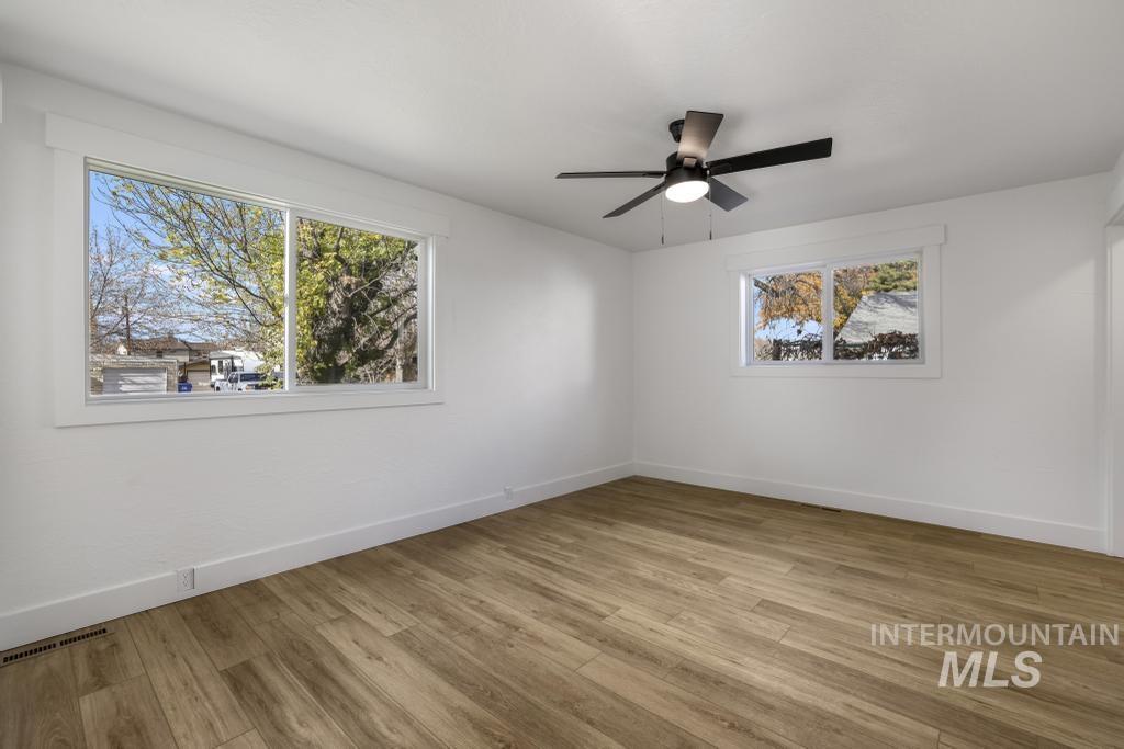 Unfurnished room with light wood-type flooring and a ceiling fan