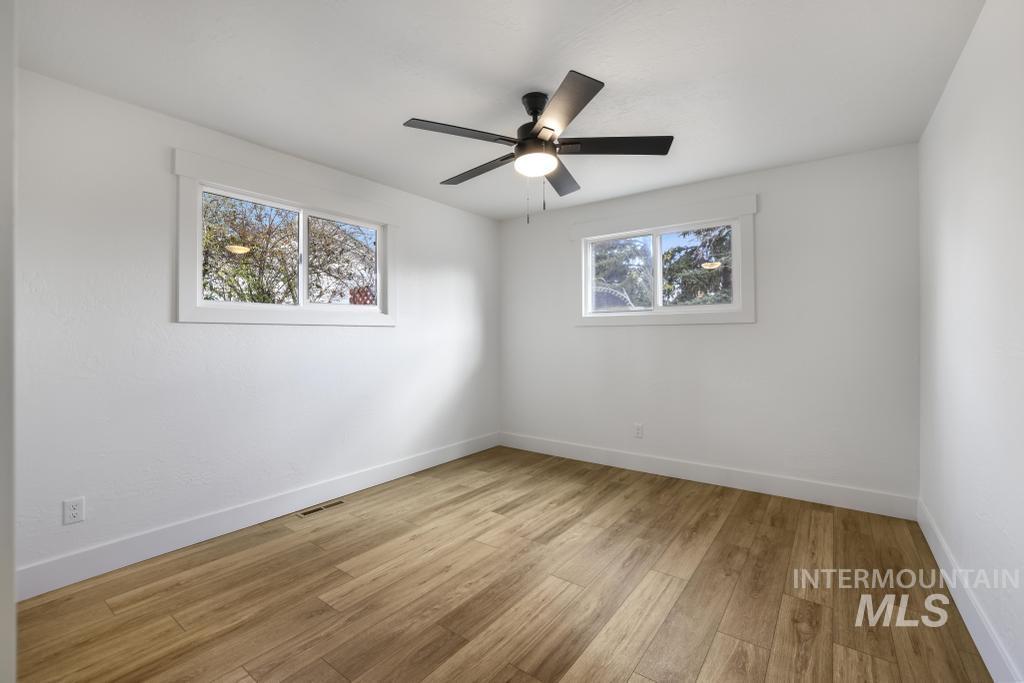 Unfurnished room featuring light wood finished floors and a ceiling fan