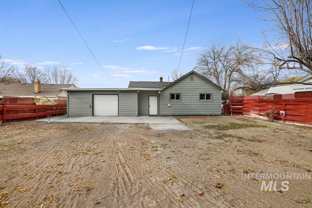 Rear view of property featuring a fenced backyard, a patio, and a garage