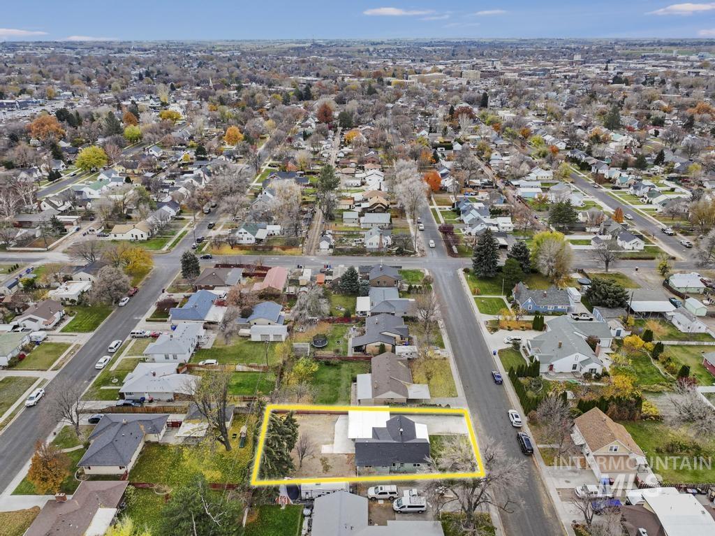Aerial view of property and surrounding area with nearby suburban area and property parcel outlined