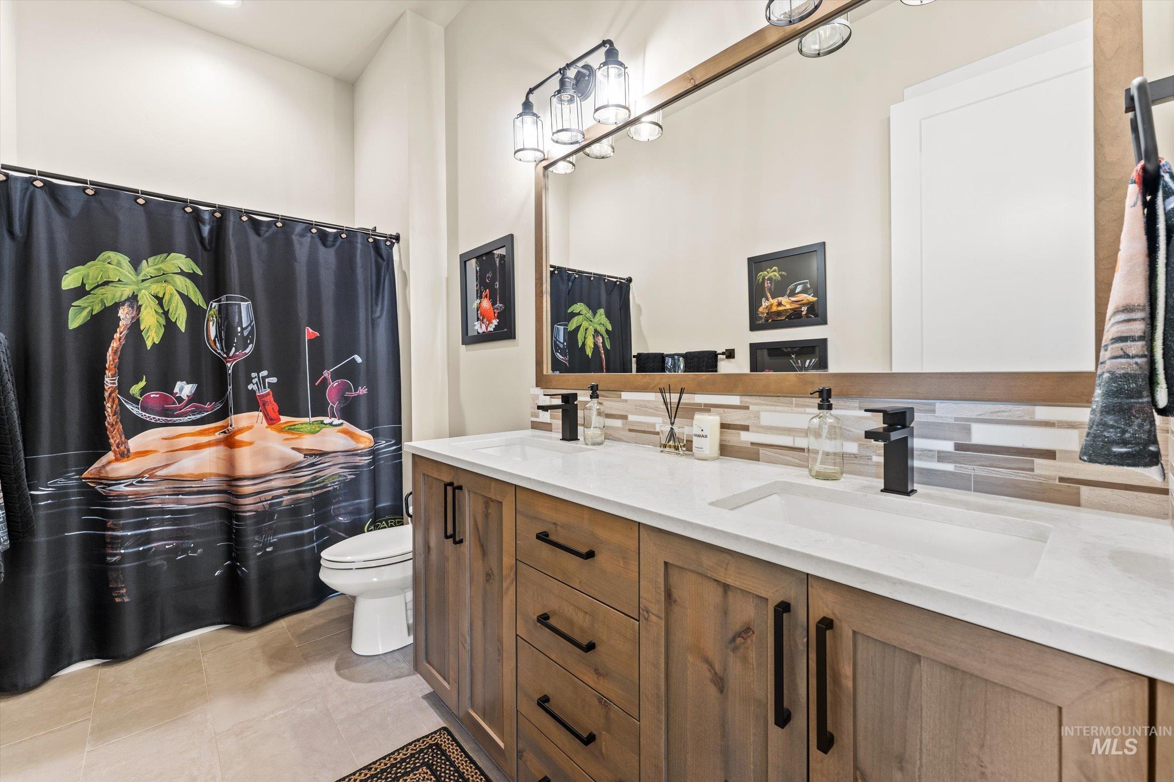 Full bath with double vanity, curtained shower, decorative backsplash, recessed lighting, and light tile patterned floors