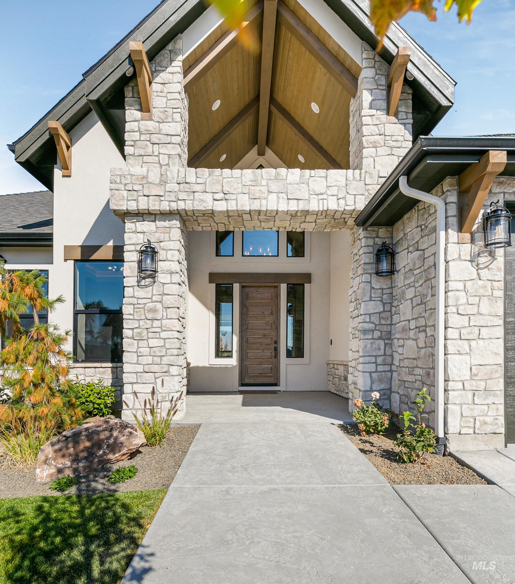 View of exterior entry featuring stone siding and stucco siding
