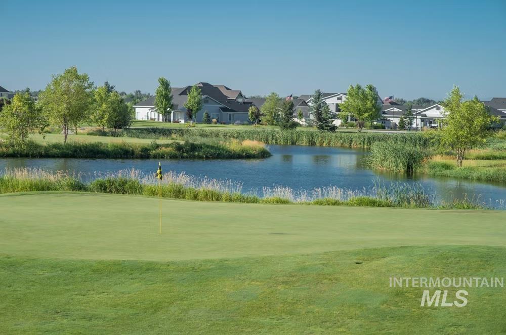 Surrounding community with a water view, an area to practice putting, and a residential view