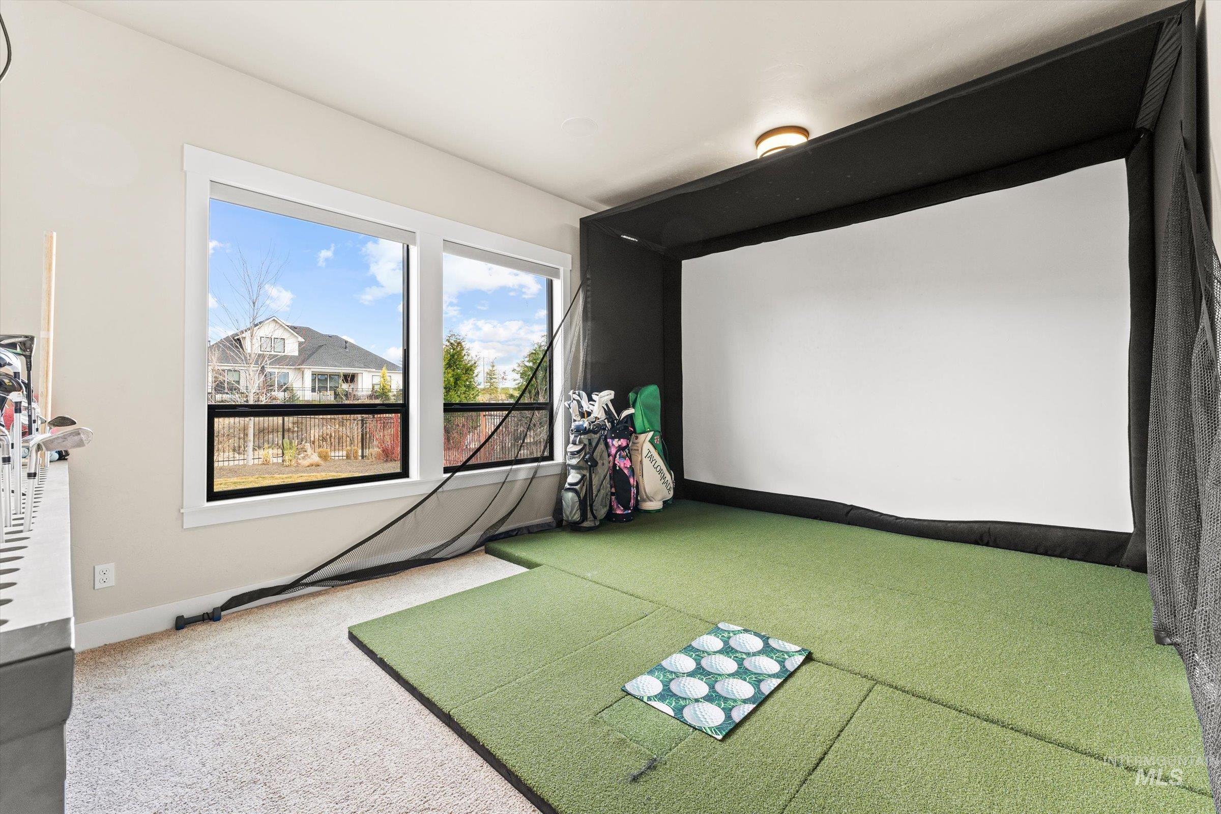 Game room with light colored carpet and golf simulator