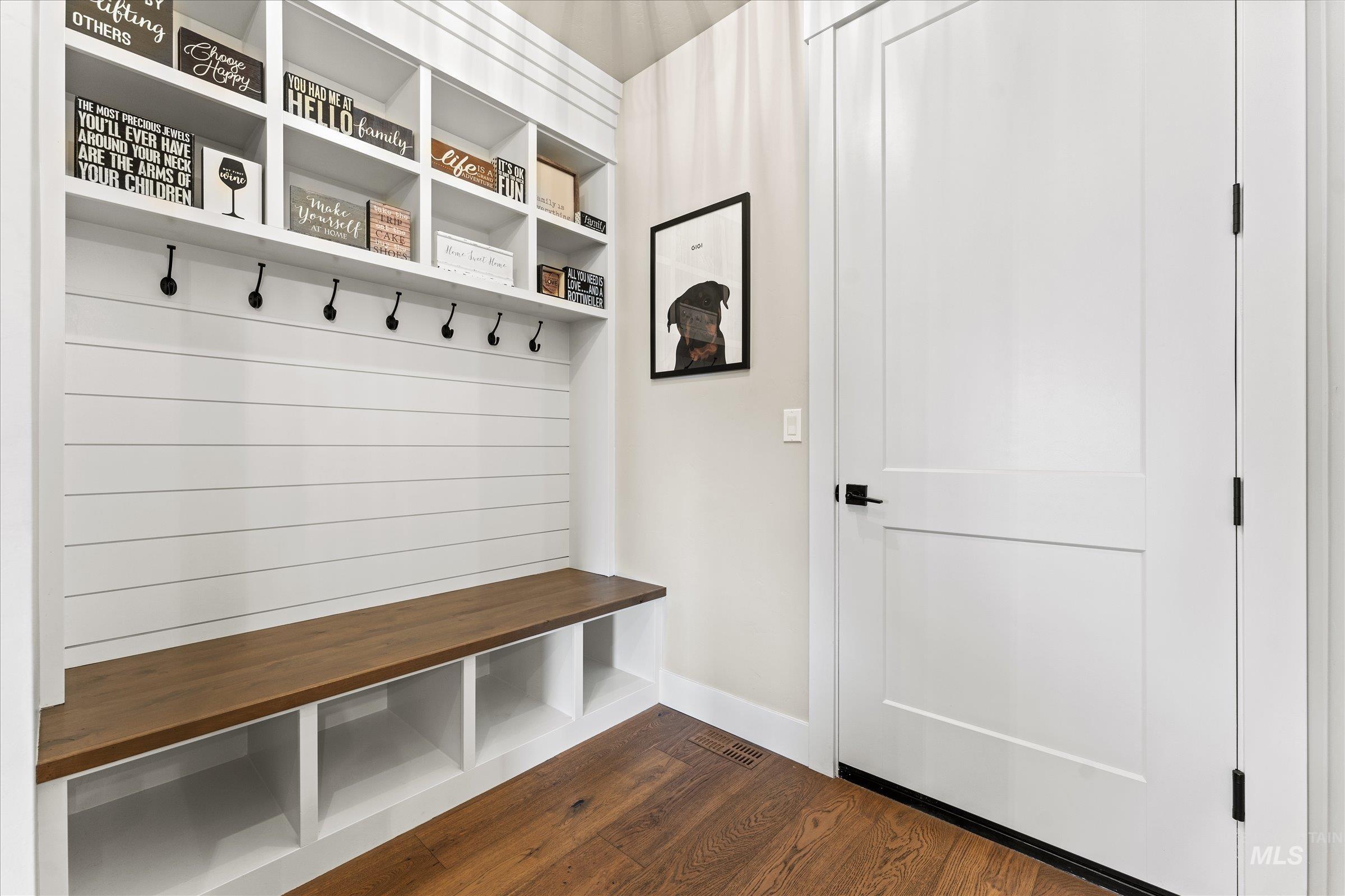 Mudroom featuring dark wood finished floors and baseboards