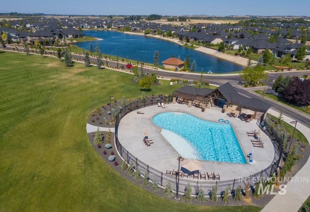 Community pool featuring a water view, a yard, a patio, and a residential view