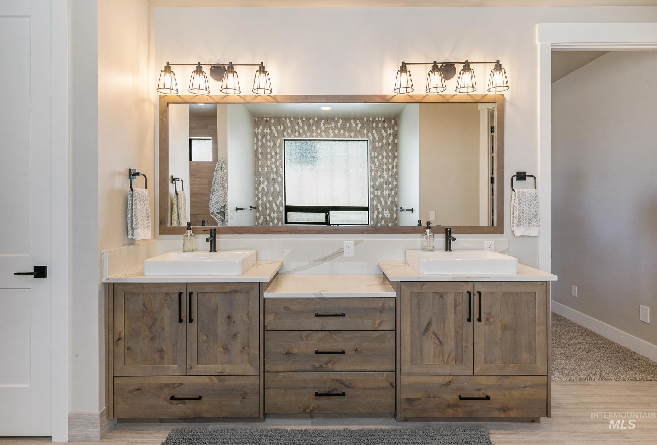 Full bath featuring double vanity and baseboards
